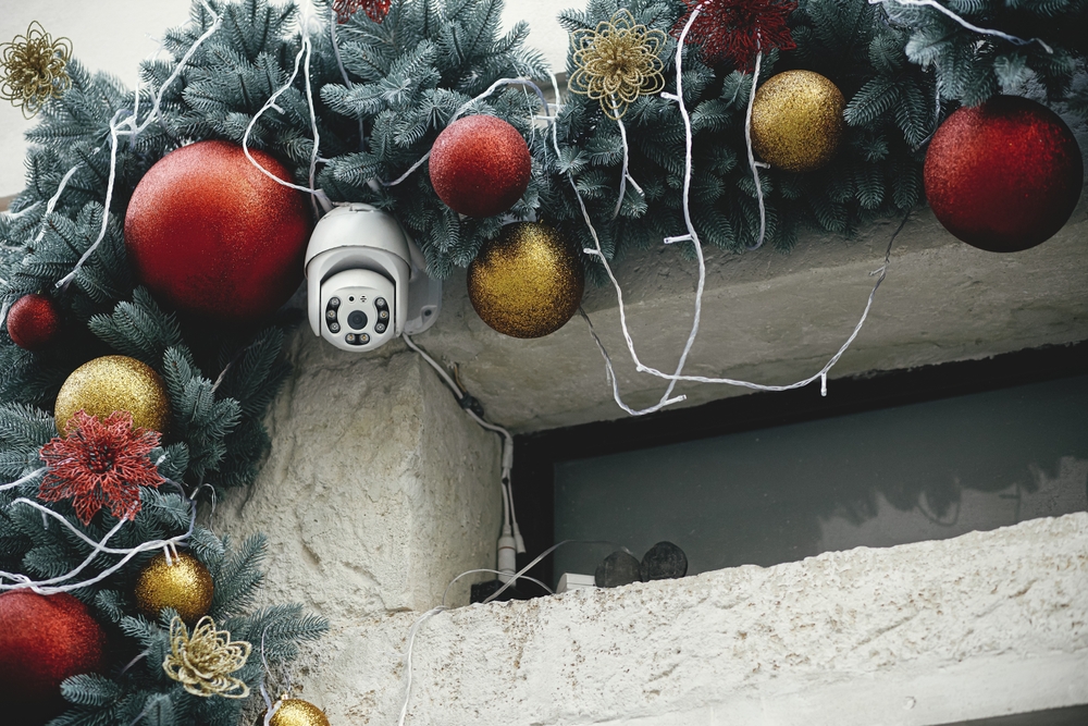 Security camera surrounded by holiday baubles, reminding people of the importance of home security during the holiday season.